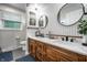 The updated bathroom features wood cabinets, granite countertops, dual sinks, and stylish fixtures at 15203 Shoreway Ct, Carmel, IN 46032