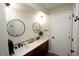 Modern bathroom with dual sinks, quartz countertop, decorative wallpaper, and round mirrors at 15203 Shoreway Ct, Carmel, IN 46032