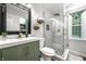 Modern bathroom with glass-enclosed shower, gray tile, and green vanity at 15203 Shoreway Ct, Carmel, IN 46032