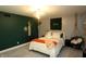Bright bedroom with carpet, a modern light fixture, dark green accent wall and stylish hanging chair at 15203 Shoreway Ct, Carmel, IN 46032
