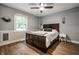 A simple bedroom featuring clean colors and hard floors has a window and a dark-stained headboard at 15203 Shoreway Ct, Carmel, IN 46032