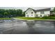 Exterior view of clubhouse featuring a tennis court, lawn, and ample parking space at 15203 Shoreway Ct, Carmel, IN 46032