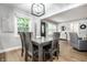 Inviting dining room featuring a dark wood table, modern lighting, and view to front entry at 15203 Shoreway Ct, Carmel, IN 46032