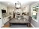 Dining room with gray wood table, seating for six, and an open floor plan to the kitchen at 15203 Shoreway Ct, Carmel, IN 46032
