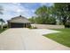 Long concrete driveway leading to a home with an attached garage, bordered by a manicured lawn and privacy fence at 15203 Shoreway Ct, Carmel, IN 46032