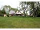 Side view of a two-story home with lush green lawn and manicured landscaping at 15203 Shoreway Ct, Carmel, IN 46032