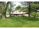 Front view of a two-story home with brick and siding, mature trees, and lush green lawn at 15203 Shoreway Ct, Carmel, IN 46032