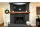 A living room fireplace with a black brick surround, wooden mantle, and a TV above at 15203 Shoreway Ct, Carmel, IN 46032