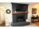 A living room fireplace with a black brick surround and a wooden mantle at 15203 Shoreway Ct, Carmel, IN 46032