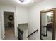 Hallway with white walls, staircase, and decorative mirror reflecting a view into the bathroom at 15203 Shoreway Ct, Carmel, IN 46032
