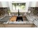 Close up of kitchen sink with stainless steel faucet, mosaic backsplash, and granite countertops at 15203 Shoreway Ct, Carmel, IN 46032