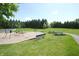 Community playground with swings, picnic tables, and benches surrounded by green grass and mature trees at 15203 Shoreway Ct, Carmel, IN 46032