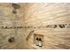 Close-up of a tiled shower with modern fixtures, a built-in niche, and mosaic accents at 15203 Shoreway Ct, Carmel, IN 46032