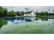Well-maintained tennis court with lighting, set against a backdrop of trees and community buildings at 15203 Shoreway Ct, Carmel, IN 46032