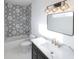Elegant bathroom featuring hexagon wall tiles, black vanity, and modern fixtures at 1525 Marlowe Ave, Indianapolis, IN 46201