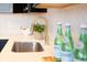 Kitchen showcasing sink with gold faucet, white countertops, and modern backsplash at 1525 Marlowe Ave, Indianapolis, IN 46201