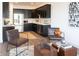 Open concept living area featuring a modern kitchen with black cabinets and stainless steel appliances at 1525 Marlowe Ave, Indianapolis, IN 46201