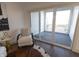 Bright living room featuring a cozy chair and a sliding glass door to the balcony at 1525 Marlowe Ave, Indianapolis, IN 46201