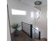 Staircase with dark hardwood floors, black railing, a hanging light fixture, and plentiful natural light at 1525 Marlowe Ave, Indianapolis, IN 46201
