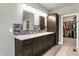 Bright bathroom featuring a double sink vanity with dark cabinets, a mosaic backsplash, and a view into a walk-in closet at 16731 George Gang Blvd, Westfield, IN 46062