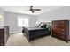 Comfortable bedroom with plush carpet, ceiling fan, natural light and stylish dark-wood furniture at 16731 George Gang Blvd, Westfield, IN 46062