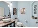 Stylish powder room featuring light blue walls, a vessel sink, mosaic backsplash and decorative wall art at 16731 George Gang Blvd, Westfield, IN 46062