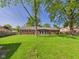 Large, green backyard with a brick home and mature trees at 1813 Kingsley Dr, Anderson, IN 46011