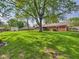 Expansive backyard with lush green lawn, brick house, and mature trees at 1813 Kingsley Dr, Anderson, IN 46011