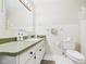 Neutral bathroom with green countertop vanity, white tile and fixtures at 1813 Kingsley Dr, Anderson, IN 46011