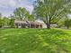 Expansive front lawn of the brick home with mature shade trees at 1813 Kingsley Dr, Anderson, IN 46011