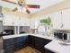 Bright kitchen featuring white and dark cabinets, plus a window view to the backyard at 1813 Kingsley Dr, Anderson, IN 46011