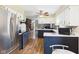 Open kitchen with stainless steel refrigerator and view into living room with fireplace at 1813 Kingsley Dr, Anderson, IN 46011