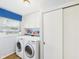 Well-lit laundry room with a front-loading washer and dryer, storage cabinets, and a window at 1813 Kingsley Dr, Anderson, IN 46011