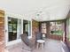 Enclosed sunroom with brick accent wall, ceiling fan, and access to the backyard at 1813 Kingsley Dr, Anderson, IN 46011