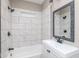 A beautifully remodeled bathroom with a tub, shower, modern vanity, and decorative framed mirror at 1921 N Dexter St, Indianapolis, IN 46202