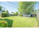 Large backyard featuring a mature tree and detached garage and carport at 1932 Central Ave, Columbus, IN 47201