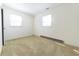 A bedroom with carpet flooring, white walls, and two windows for ample natural light at 1932 Central Ave, Columbus, IN 47201