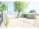 View of detached garage with carport and concrete driveway, surrounded by mature trees and privacy fence at 1932 Central Ave, Columbus, IN 47201