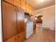 A kitchen with wood cabinets and white appliances adjacent to another living space at 1932 Central Ave, Columbus, IN 47201