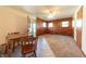 Living room with wood paneled wall and windows adjacent to table and chairs at 1932 Central Ave, Columbus, IN 47201