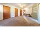 Bright living room with multiple closets, and wood paneled doors with carpet flooring at 1932 Central Ave, Columbus, IN 47201