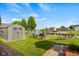 This backyard features lake access, a shed, seating, a swing and beautiful green space at 1969 Westminster Pl, Columbus, IN 47201