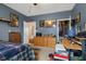 Bedroom with blue walls, desk, shelving and interesting personal items at 1969 Westminster Pl, Columbus, IN 47201