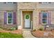Inviting home entrance features a classic white door, brick accents, and colorful landscaping at 1969 Westminster Pl, Columbus, IN 47201