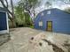 Backyard featuring a concrete patio area connecting to a home with secure door and boarded window at 2324 E 36Th St, Indianapolis, IN 46218