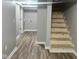 Basement features wood-look flooring, unfinished stairs, and white trim at 2324 E 36Th St, Indianapolis, IN 46218