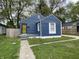 Charming blue bungalow with a yellow security door and well-maintained lawn at 2324 E 36Th St, Indianapolis, IN 46218