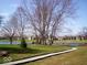 A picturesque view of the community grounds, featuring a pond, gazebo and lush green space at 2829 Somerset Bay, Indianapolis, IN 46240