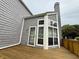 Exterior angle shows large windows and an outside entrance to a charming gray home with wood deck at 2829 Somerset Bay, Indianapolis, IN 46240