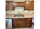 A view of the kitchen sink and tile backsplash with stainless steel appliances and brown cabinets at 2829 Somerset Bay, Indianapolis, IN 46240